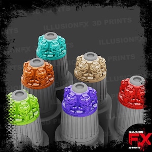 May include: A collection of colorful, decorative toppers with a skull and wing design. The toppers are in various colors, including teal, orange, beige, green, purple, and red. The text "ILLUSION FX 3D PRINTS" is visible.