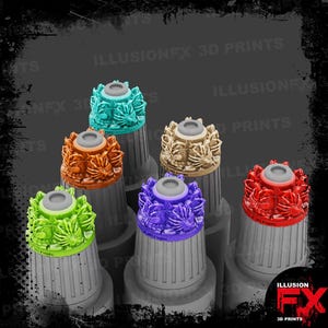 May include: A collection of colorful 3D-printed bottle stoppers. Each stopper features a decorative leaf design in various colors, including teal, orange, beige, green, purple, and red. The stoppers are displayed on gray cylindrical bases.