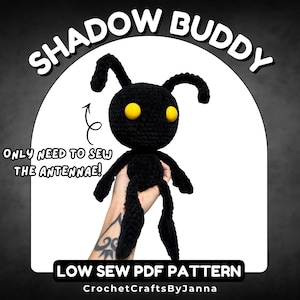 Może przedstawiać: Czarny szydełkowy pluszak Shadow Buddy z żółtymi oczami i antenami. Tekst "SHADOW BUDDY" znajduje się na górze, a "ONLY NEED TO SEW THE ANTENNAE!" poniżej. Na dole widnieje napis "LOW SEW PDF PATTERN" i "CrochetCraftsByJanna".