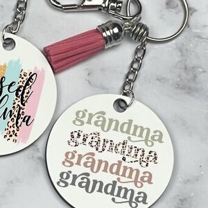 May include: Keychain with a pink tassel and a round tag that says "grandma" four times in different fonts and colors.