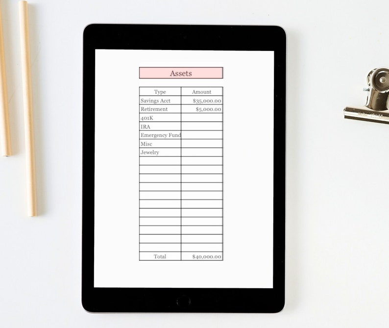 K&ouml;nnte beinhalten: Ein digitales Tablet zeigt ein Finanzanlagen-Tracking-Sheet. Das Sheet enth&auml;lt Kategorien wie Savings Acct, Retirement und IRA, mit einem Gesamtverm&ouml;genswert von 36.000 &euro;. Das Tablet liegt auf einer wei&szlig;en Oberfl&auml;che, mit einer silbernen Klammer und Bleistiften in der N&auml;he.