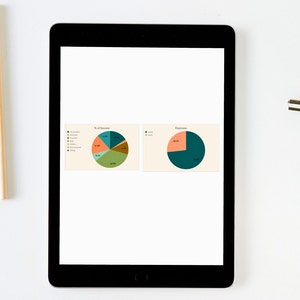 Puede incluir: Una tableta negra muestra dos gr&aacute;ficos circulares sobre un fondo blanco. Los gr&aacute;ficos muestran porcentajes de ingresos y gastos, con segmentos de varios colores. Se ven un l&aacute;piz y un clip.