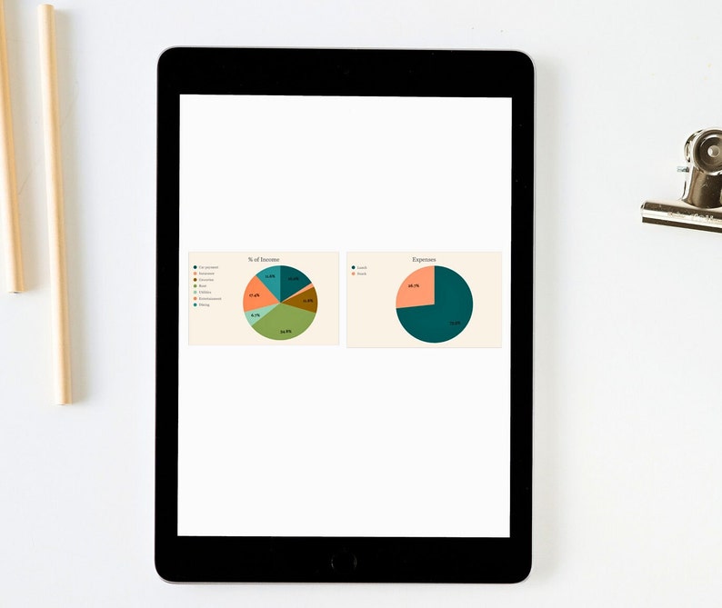 Puede incluir: Una tableta negra muestra dos gr&aacute;ficos circulares sobre un fondo blanco. Los gr&aacute;ficos muestran porcentajes de ingresos y gastos, con segmentos de varios colores. Se ven un l&aacute;piz y un clip.