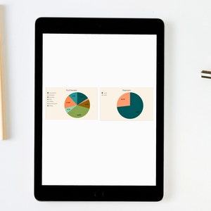 K&ouml;nnte beinhalten: Ein schwarzes Tablet zeigt zwei Kreisdiagramme auf wei&szlig;em Hintergrund. Die Diagramme zeigen Prozents&auml;tze von Einnahmen und Ausgaben mit verschiedenen farbigen Segmenten. Das Tablet liegt auf einer wei&szlig;en Oberfl&auml;che mit Bleistiften und einer Klammer.