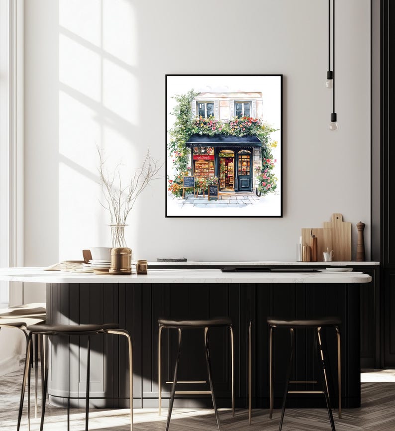 May include: A watercolor painting of a storefront with a black awning and a sign that reads "Le Petit March&eacute;". The storefront is decorated with flowers and greenery. The building is white with black trim. The painting is framed in a black frame.
