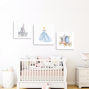 May include: Three watercolor prints featuring Cinderella themed imagery. The first print shows Cinderella's castle, the second print shows Cinderella in her blue ball gown, and the third print shows Cinderella's carriage.