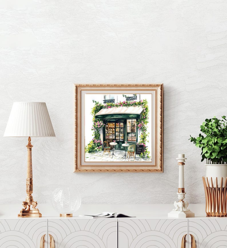 May include: A watercolor painting of a green storefront with a white awning and a sign that reads "Patisserie". The storefront is decorated with flowers and there are two tables with chairs outside.