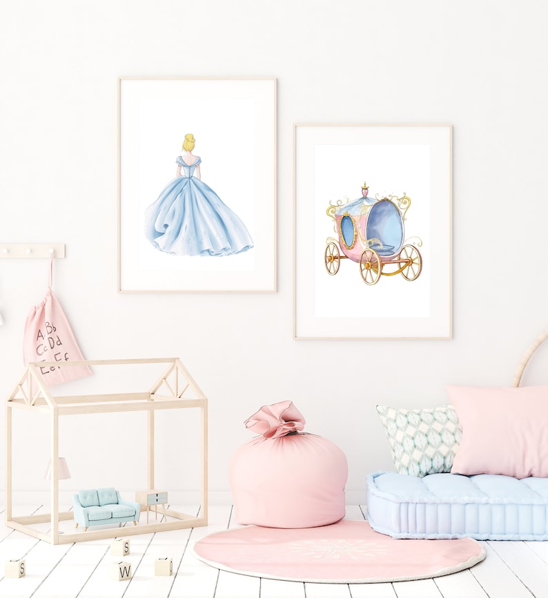 May include: Two framed prints, one with a watercolor illustration of Cinderella in a blue ball gown, the other with a pink and gold carriage.
