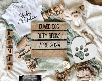 May include: A baby announcement with a white onesie that says "Baby Mc Queen", a wooden sign that says "Guard Dog Duty Begins April 2024", a wooden bone with the words "Coming Soon", a stuffed dog toy, and a heart-shaped wooden cutout with a paw print.
