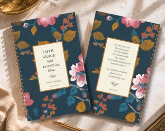 May include: Two spiral-bound prayer journals with a dark blue background featuring a floral pattern of pink flowers and gold leaves. The left journal cover reads: FAITH. GRACE. And Everything Else. Prayer Journal Lisa Kanova. The right cover has text.