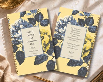 May include: Two spiral-bound prayer journals with a yellow background and dark blue floral pattern. The left journal cover reads: FAITH. GRACE. And Everything Else. Prayer Journal Lisa Kanove. The right journal cover features a quote from 1 Corinthians 16:14.
