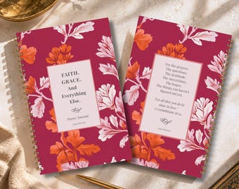 May include: Two spiral-bound prayer journals with a deep magenta background featuring orange and white floral patterns. The left journal cover reads "FAITH. GRACE. And Everything Else. Prayer Journal Lisa Kanove". The right cover features text.
