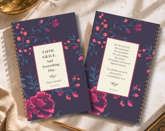 May include: Two spiral-bound prayer journals with dark purple covers featuring pink and dark blue floral patterns. The left journal reads: FAITH. GRACE. And Everything Else. Prayer Journal Lisa Kanova. The right journal features a religious quote.