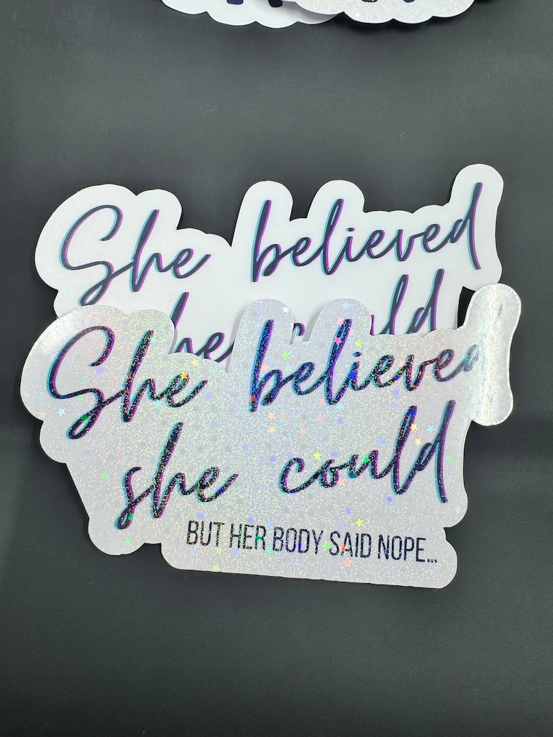 May include: A white sticker with glitter and a black cursive font that reads "She believed she could but her body said nope..."
