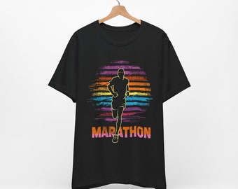 Puede incluir: Camiseta negra con una silueta de un corredor sobre un gráfico de puesta de sol colorido. El texto "MARATHON" está impreso debajo del gráfico.