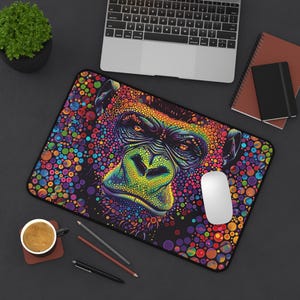 May include: A colourful mouse mat with a psychedelic gorilla face design. The gorilla's face is made up of small, colourful dots. The background is black with colourful dots.