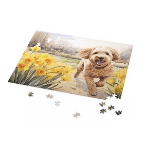 May include: A jigsaw puzzle depicting a watercolour illustration of a happy, light brown dog running through a field of yellow daffodils. Several puzzle pieces are scattered around the partially assembled puzzle.