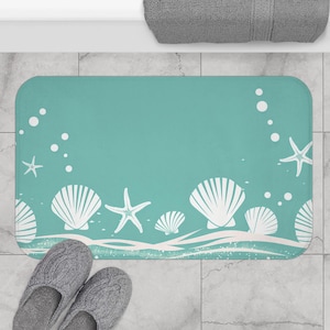 May include: A teal blue bath mat with a white wave design and white seashells and starfish.