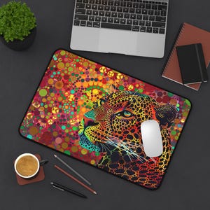 Puede incluir: Una alfombrilla de ratón colorida con un diseño de estampado de leopardo. La cara del leopardo está en primer plano, con un fondo de círculos coloridos.