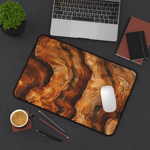 May include: A brown and black wood grain mouse pad with a white computer mouse on top of it. The mouse pad is on a dark gray surface.