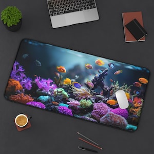Peut inclure: Un tapis de souris coloré avec une scène sous-marine vibrante mettant en scène des récifs coralliens, des poissons colorés et une souris d'ordinateur blanche.
