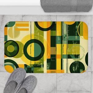 May include: Abstract bath mat with a geometric pattern of overlapping circles and rectangles in shades of yellow, green, and brown.