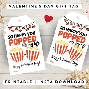 May include: Printable Valentine's Day gift tag with a popcorn theme. The tag features two cartoon popcorn buckets with faces and the text "So happy you popped into my life". The tag is 2 inches by 3 inches.