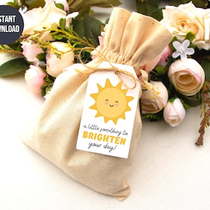 May include: A small white gift tag with a yellow sun illustration and the text "a little something to BRIGHTEN your day!"