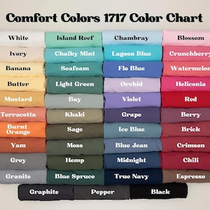 May include: A color chart titled "Comfort Colors 1717 Color Chart" displays a variety of fabric colors. The chart includes shades like white, blue, pink, orange, and green. Each color is labeled with its name, such as "Blossom" and "True Navy".