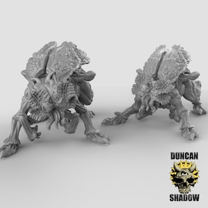 May include: Two gray, detailed, 3D printed miniature creatures with segmented bodies and multiple legs. The creatures have a textured, organic appearance.