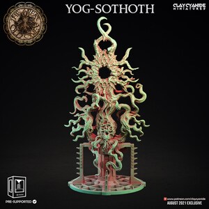 May include: A 3D printed miniature of Yog-Sothoth, a cosmic entity from the Cthulhu Mythos. The figure is green and pink, with a large, central eye and many tentacles. The figure is standing on a base with a circular design.