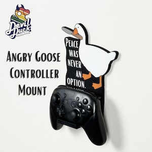 May include: A white goose with a knife in its beak, holding a black Nintendo Switch controller. The goose is standing on a black and white background with the text "Peace was never an option."  The text "Angry Goose Controller Mount" is written in white letters on a black background.