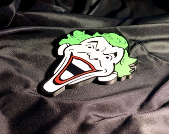 Könnte beinhalten: Ein 3D-gedrucktes Joker-Gesicht mit weißen und roten Details und grünen Haaren. Der Joker lächelt mit einem breiten, übertriebenen Grinsen.