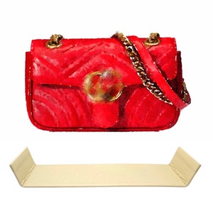 Peut inclure: Un sac à main matelassé rouge avec une bandoulière en chaîne dorée et un accent circulaire doré sur le rabat avant.