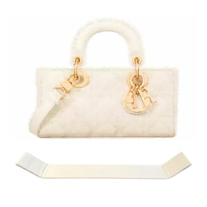 Puede incluir: Un bolso de mano acolchado blanco con herrajes dorados y asa superior. El bolso tiene un logotipo 'CD' en la parte delantera.