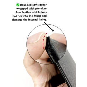 May include: Close-up of a black leather wallet corner showing a rounded edge and a stitched seam. The corner is wrapped with faux leather to prevent damage to the fabric lining.