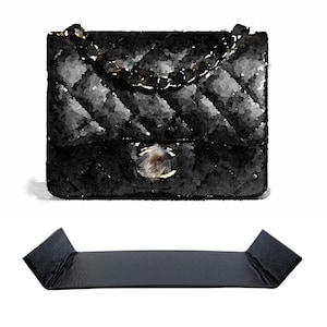 Könnte beinhalten: Eine schwarze gesteppte Handtasche mit einer goldenen Kettenriemen und einem goldenen Verschluss. Die Tasche ist aus Leder und hat eine rechteckige Form.