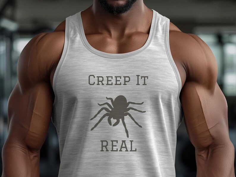 Peut inclure: D&eacute;bardeur gris clair avec l'inscription "CREEP IT REAL" en gris fonc&eacute; au-dessus et en dessous d'un dessin d'araign&eacute;e. Le d&eacute;bardeur est sans manches et en mati&egrave;re souple.