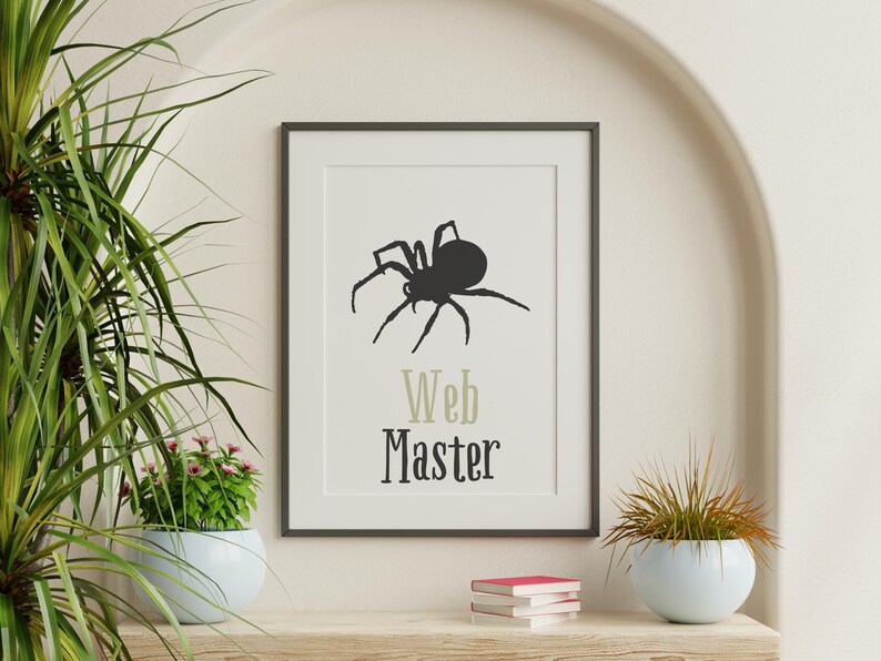 Peut inclure: Impression encadr&eacute;e avec une silhouette d'araign&eacute;e noire et les mots "Web Master". L'impression est dans un cadre noir, pos&eacute;e sur une &eacute;tag&egrave;re en bois avec des livres et une plante en pot. Le fond est de couleur neutre. Th&egrave;me d'Halloween.