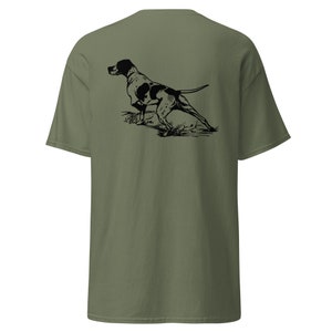 May include: A green t-shirt with a black and white illustration of a hunting dog on the back.