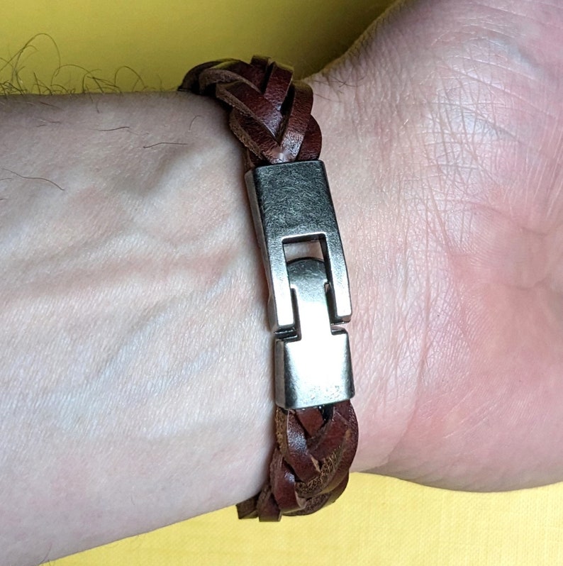May include: A brown leather braided bracelet with a silver clasp.
