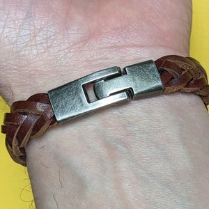 May include: A brown leather braided bracelet with a silver metal clasp.