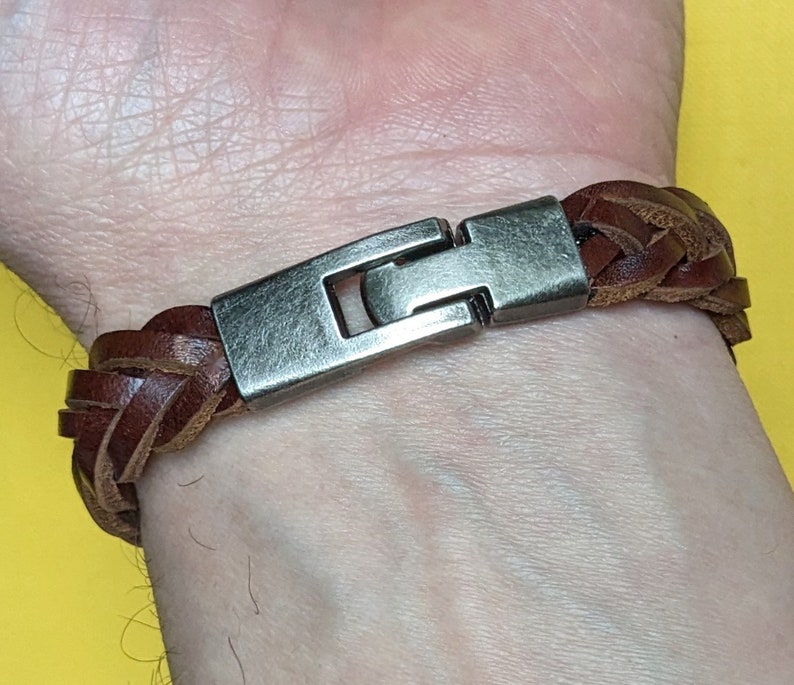 May include: A brown leather braided bracelet with a silver metal clasp.