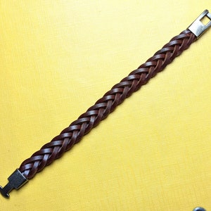 May include: A brown leather braided bracelet with silver metal clasps.