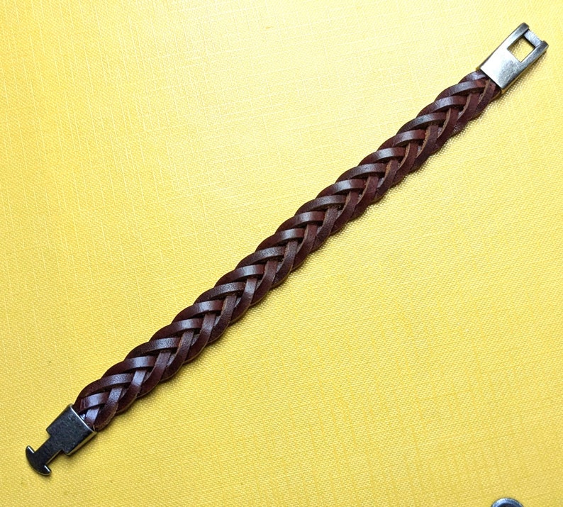 May include: A brown leather braided bracelet with silver metal clasps.