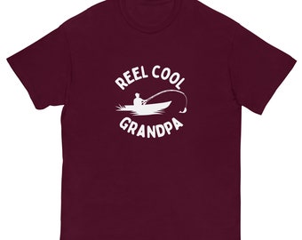 May include: Burgundy short-sleeved t-shirt with a white graphic of a person fishing in a boat with the text "Reel Cool Grandpa".