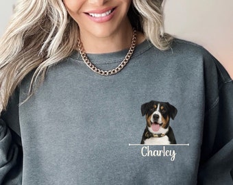 May include: A gray sweatshirt with a pocket featuring a black and white dog with a red collar. The dog's name, "Charley", is printed below the image.