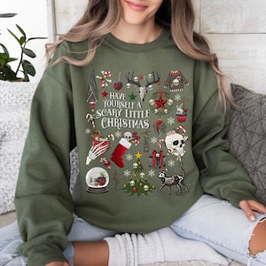 May include: Green sweatshirt with a festive, spooky Christmas design. It features skulls, candy canes, a Christmas tree, and the text "Have Yourself a Scary Little Christmas".