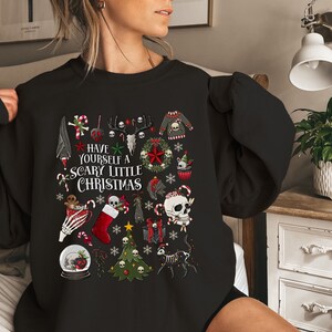 May include: Black sweatshirt with a festive Christmas design featuring skulls, candy canes, and the text "Have yourself a scary little Christmas".