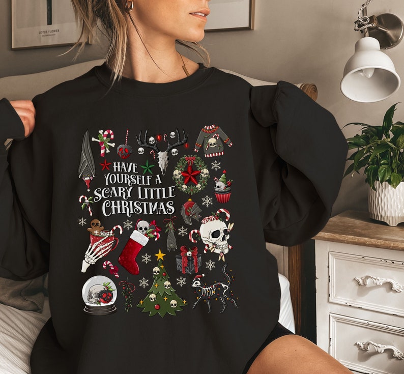 May include: Black sweatshirt with a festive Christmas design featuring skulls, candy canes, and the text "Have yourself a scary little Christmas".